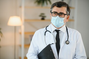 male doctor with medical face mask and a stethoscope at clinic