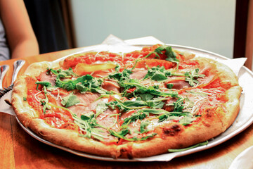 Sliced pieces of spinach greek style pizzas at a restaurant table.