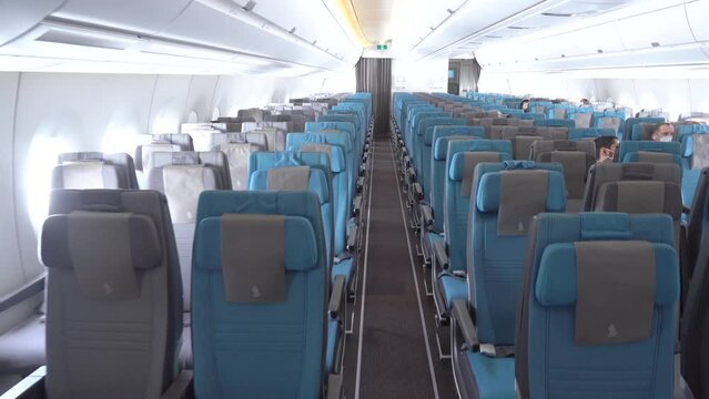 Person's POV Walking In The Aisle Passing On Empty Seats With Few People In Mask During The Spread Of Deadly Coronavirus.