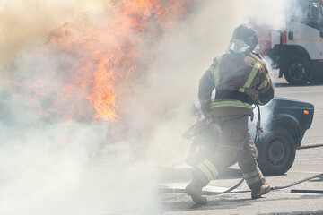 Firefighters attack a propane fire. Fireman Putting Out Fire. Firemen extinguishing a car fire....