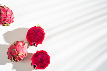 Juicy ripe pitahaya whole and scattered on a white background. View from above. Hard light, shadow...