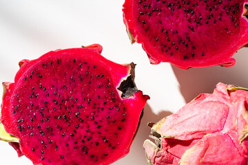 Juicy ripe pitahaya whole and scattered on a white background. View from above. Hard light, shadow...