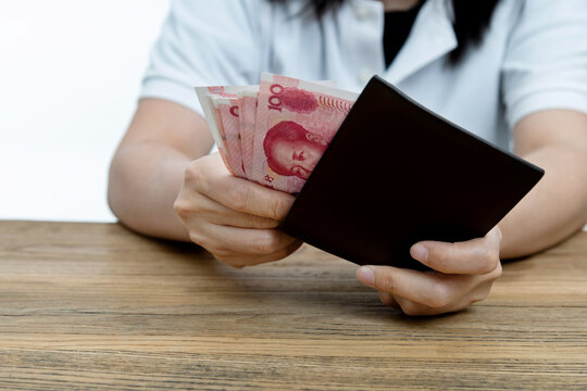 Woman hand holding a leather wallet with Chinese Renminbi