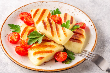 Grilled halloumi cheese served with tomatoes and parsley