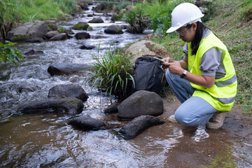 Environmental engineers inspect water quality at natural water sources and record data on...