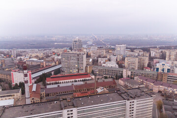 Ukraine, Kyiv – March 12, 2016: Aerial panoramic view on central part of Kyiv city from a roof of a high-rise building. Night life in a big city. Foggy and rainy weather. 