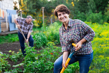 woman farmer posing and digging in her estate garden