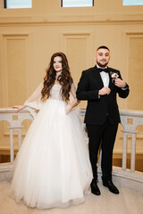 Beautiful wedding couple. Happy bride and luxurious husband. Marble staircase