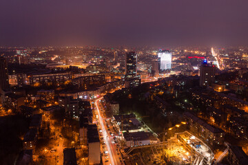Ukraine, Kyiv – March 12, 2016: Aerial panoramic view on central part of Kyiv city from a roof of a high-rise building. Night life in a big city. Foggy and rainy weather. 
