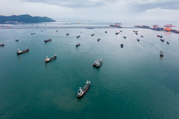 group of transport ships waiting to carry oil,gas,petrochemicals for export,floating in sea at evening rain strom background aerial view