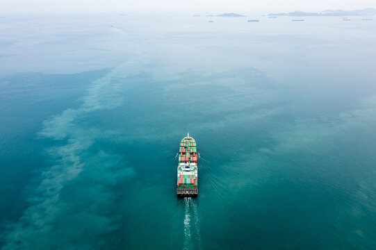 Container ship full speed sailing in sea for transporting cargo logistic import and export goods internationally around the world, including Asia Pacific and Europe, Aerial view