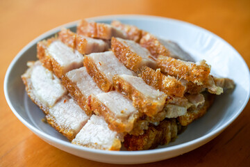 Close-up of a plate of golden and attractive crispy roasted pork, with meat