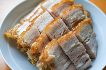 Close-up of a plate of golden and attractive crispy roasted pork, with meat