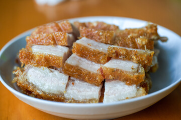 Close-up of a plate of golden and attractive crispy roasted pork, with meat