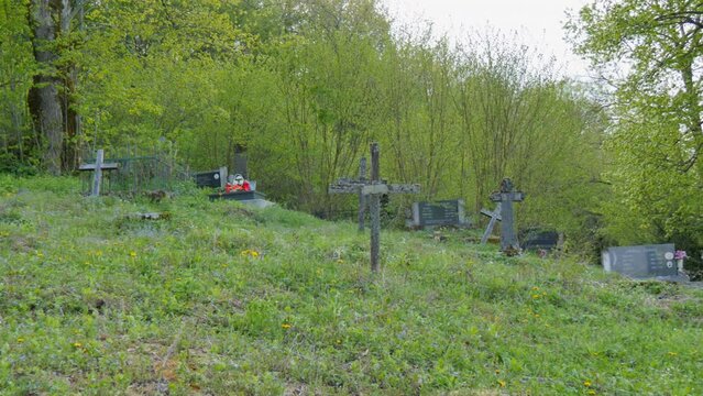 Cross signs in the village of Smiljan graveyard, Nikola Tesla's birthplace. Forest-covered hills surround the green valley. Lika region. 