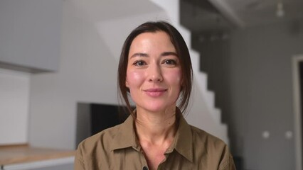 Young smiling Asian female on an online interview or making video call, sitting at desk and looking waving at camera, saying hello, woman takes a part in virtiual meeting. Job hunting. - Powered by Adobe