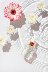 Cosmetic bottle with pipette and flowers.