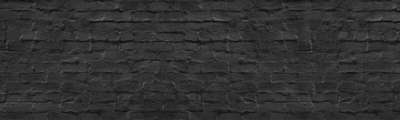 Old black painted plastered brick wall wide texture. Dark gray rough masonry long backdrop. Gloomy grunge panoramic background