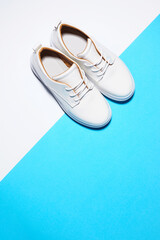 Fototapeta na wymiar Trendy leather female sneakers. White milky color,