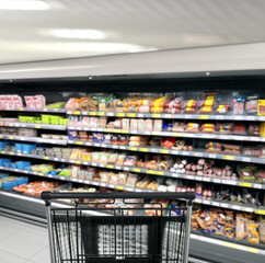 choosing a dairy products at supermarket.empty grocery cart in an empty supermarket