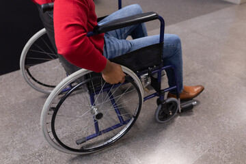 Obraz premium Low section of young african american disabled businessman in wheelchair at workplace