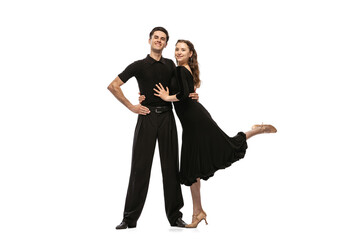 Two young graceful dancers wearing black stage outfits dancing ballroom dance isolated on white background. Concept of art, beauty, music, style. - obrazy, fototapety, plakaty