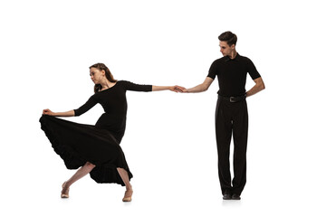 Dynamic portrait of young emotive dancers in black outfits dancing ballroom dance isolated on white background. Concept of art, beauty, music, style.