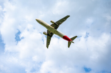 Beautiful panoramic background with flying plane in blue sky. The passenger plane with the landing...