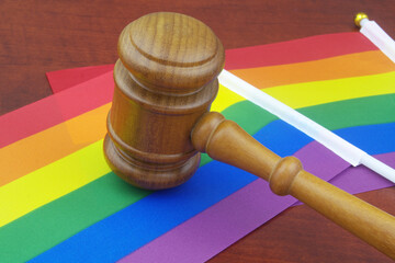 LGBT rights, equality and laws concept. Wooden judge gavel with LGBT flags.	