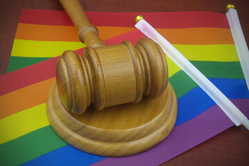 LGBT rights, equality and law concept. Judge gavel with LGBT flags close up.	
