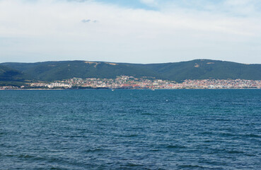 Black sea, blue water, hotels of resort area where people rest are visible in distance, against the...