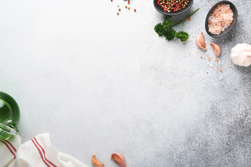 Food cooking background. Stone texture with sea salt, pepper garlic and parsley on light grey. Abstract food background. Empty space for text. Can be used for food posters, design of menu. Top view.