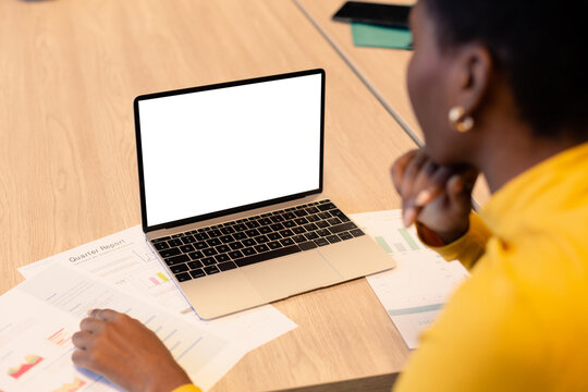 African American Female Advisor Looking At Copy Space On Blank Laptop Screen In Workplace