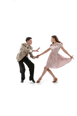 Young man and woman in vintage retro style outfits dancing social dance isolated on white background. Timeless traditions, 1960s american fashion style and art