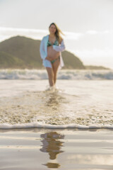 pregnant woman walking by the sea