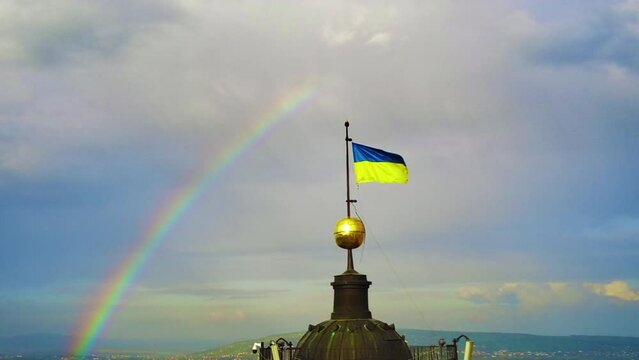 Waving ukrainian flag in slow motion against the rainbow background