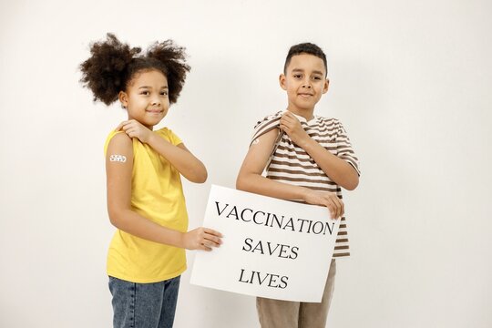 Two Multiracial Kids Holding A Poster That Vaccination Saved Lives