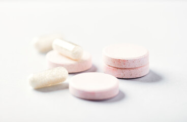 Collagen effervescent Tablets and Vitamin C capsules. Supplements to support collagen production. Bright paper background. Soft focus. Close up.	