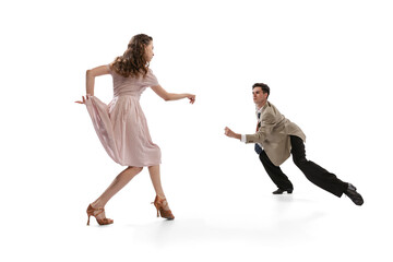 Young man and woman in vintage retro style outfits dancing social dance isolated on white background. Timeless traditions, 1960s american fashion style and art