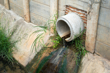 Industrial sewage water draining out from cement tube into the environmental. Industrial pollution...