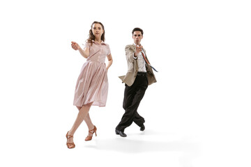 Young man and woman in vintage retro style outfits dancing social dance isolated on white background. Timeless traditions, 1960s american fashion style and art