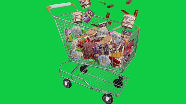 Cheese, eggs, chocolate, books, soccer balls, margarine, preserves in the shopping cart. Economy, spending money and shopping concept on green background