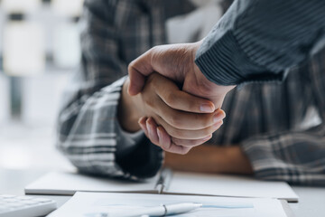 Obraz premium Close-up two business men holding hands, Two businessmen are agreeing on business together and shaking hands after a successful negotiation. Handshaking is a Western greeting or congratulation.