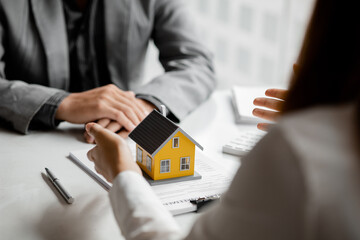 Real estate agents explain models of housing estates in projects to elaborate to clients,...