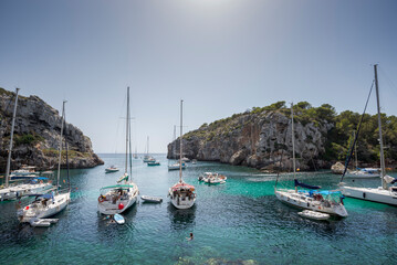 Sailing boats anchored in Cales Coves, a famous cove in the municipality of Alaior, Menorca, Spain