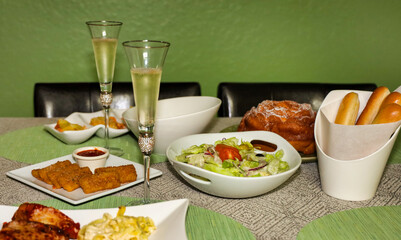 View of a dinner table served with a full meal for two.