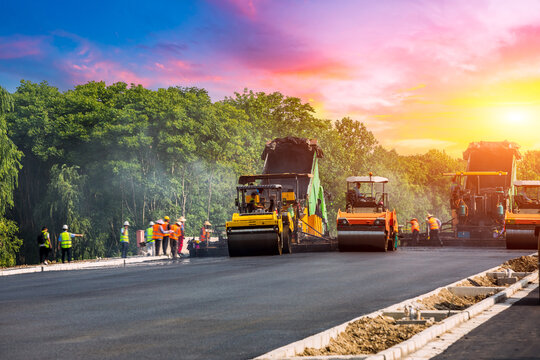 Construction site is laying new asphalt pavement. road construction workers and road construction machinery scenery. Highway construction site scene in China.