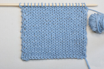 needlework in light blue yarn isolated on white background