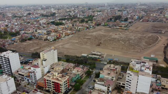 Ancient Inca site in Lima Peru called "Huaca San Mateo" Drone video recorded while turning right while flying left. Many residential buildings and houses can be seen around the archaeological site.