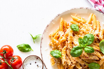 Pasta with tomato sauce, basil and parmesan in white plate. Top view image with copy space, close up.